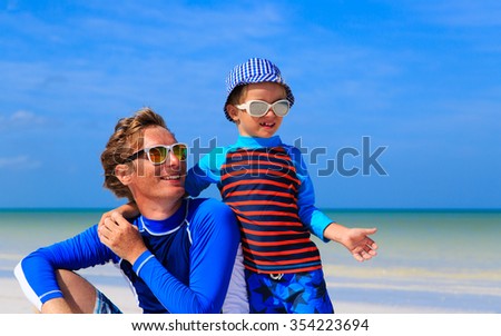 father and little son hug on summer beach, family lifestyle