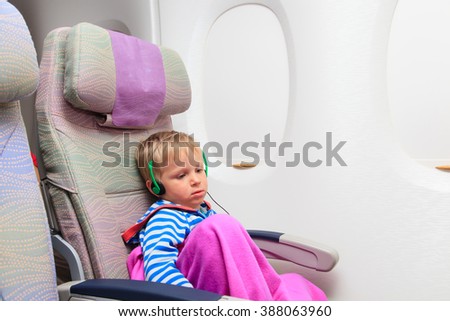 little boy with headset watching tv in flight