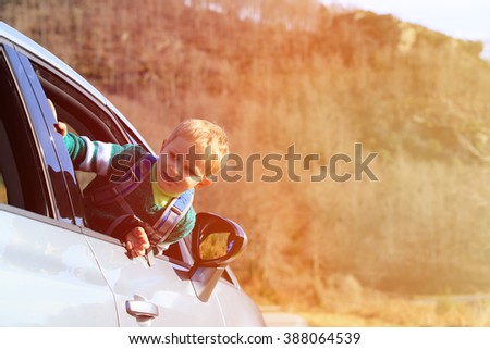 little boy travel by car in autumn nature