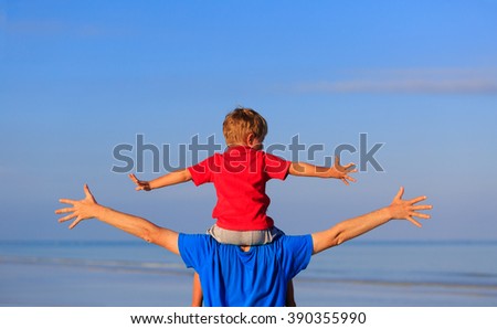 happy father and son playing on sea