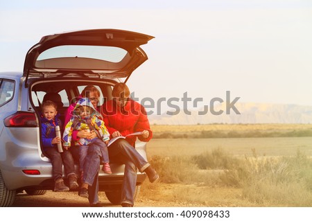 family with two kids travel by car in mountains