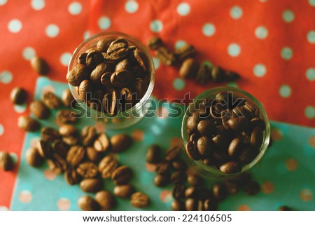 coffee beans in small cup on colorful polka dot texture with retro filter effect or instagram filter