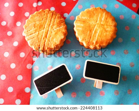 Tasty vanilla cookies and blank small tiny black board polka dot paper in warm tone