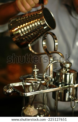 hand of barista  pouring dripping water for coffee,making coffee with Belgian Royal style Syphon or siphon Coffee Maker