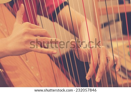 Closeup of a woman playing the harp in rehearsal room with retro filter effect lighting or instagram filter