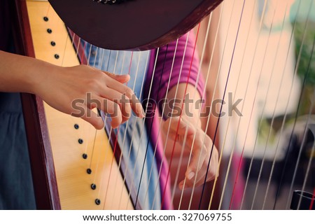 Closeup of a woman playing the harp with soft retro filter effect lighting or instagram filter