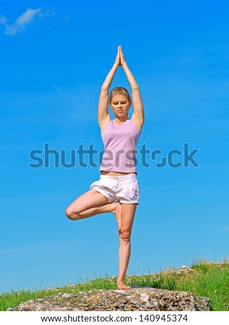 Meditation over sky background. Yoga woman on the hill.