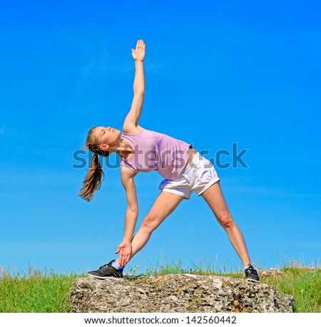 Yoga woman on the nature. Sporty young female in yoga pose on the stone.