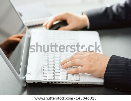 Close-up of financial manager\'s hands working at laptop in bureau. Business analyst making forecast of corporate funds.