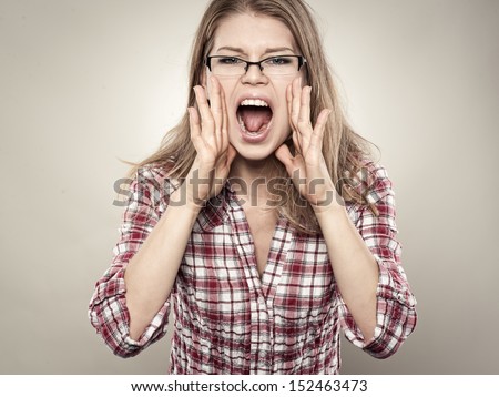 Pretty girl screaming out loud. Young lovely emotional woman with open mouth posing in studio.