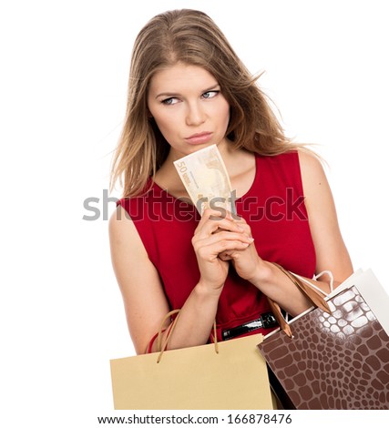 Sad thinking female shopper with shopping bags holding money.