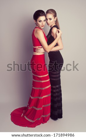 Fashion rich people. Young attractive glamour models in expensive evening clothes posing in studio.