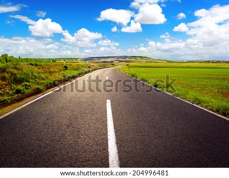 Concept of straight path to success. Asphalt road over blue sky background.