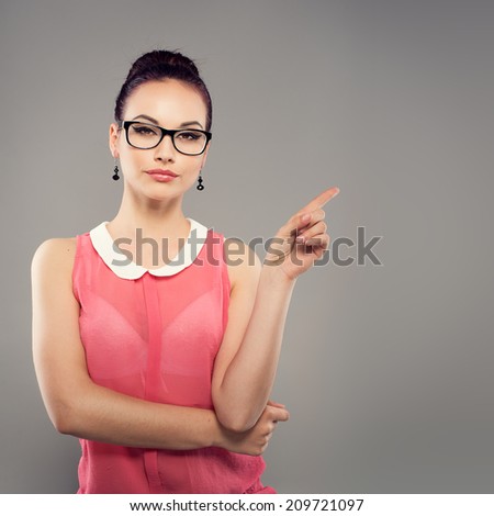 Stylish brunette wearing modern eyeglasses pointing at copy space Portrait of beautiful fashionable dressed woman in spectacles Stylish brunette wearing modern eyeglasses pointing at copy space Portrait of beautiful fashionable dressed woman in spectacles