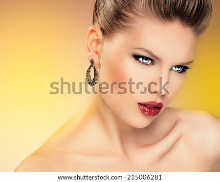 Close-up portrait of young hot glamour lady with blue eyes wearing luxury jewelery. Fashionable cute Caucasian woman with professional make-up posing in studio.