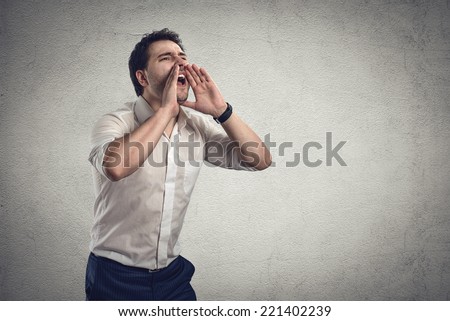 Portrait of young stressed business guy screaming loud in fury.  Male speaker yelling for help. Financial crash or crisis concept.