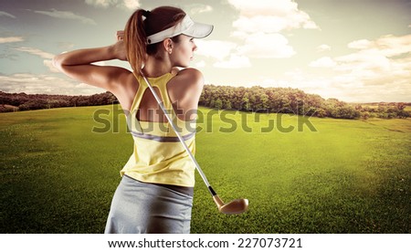 Young female in sportswear playing golf on green field. Active fresh Caucasian woman swinging with golf club.