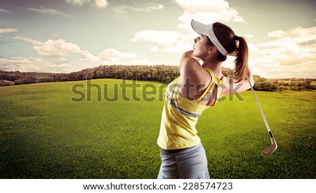 Sporty young female playing golf on the nature. Active girl in sportswear golfing in green field.