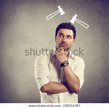 Conceptual shoot of young thinking businessman with drawn hummers above his head.