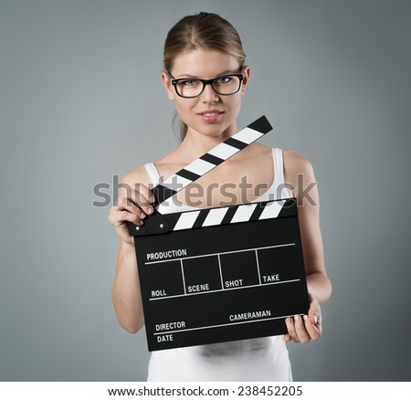 Portrait of pretty woman holding clapperboard. Film production and movie making concept.