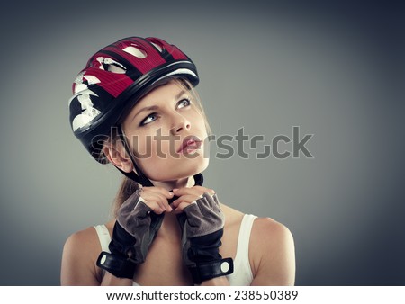 Cycling. Woman putting biking helmet before ride. Portrait of young female athlete professional sportswoman.