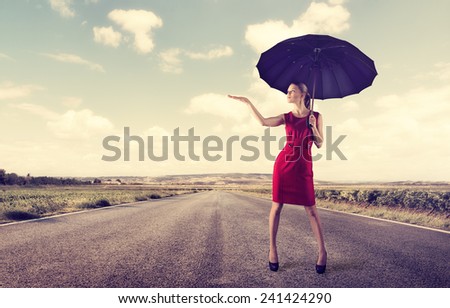 Fashionable female with umbrella standing on highway at sunny day. Concept of protection from trouble or difficulties. Successful business.