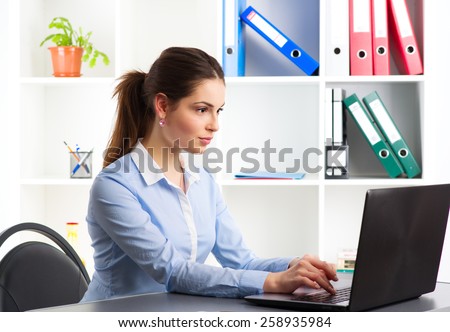 On-line job. Young woman communicating with partners via internet. Confident sales person working at laptop in the office.