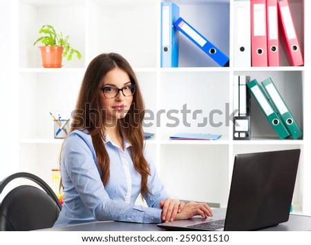 Young female general manager working at computer in her agency. Concept of new projects, ideas and success.