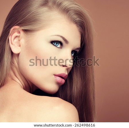 Hair extension and styling. Closeup portrait of young gorgeous female model with long straight healthy hair posing in studio.