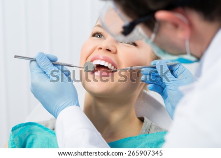 Regular dentist visit. Caries cure. Young woman visiting dentist surgeon in hospital.