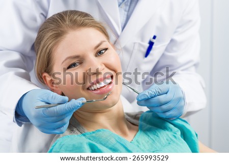 Close-up portrait of happy smiling dental care woman taking oral treatment in dentist office. Infected gum or tooth cure.