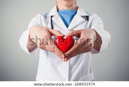 Close-up of female doctor\'s hands holding heart shape. Concept of heart disease protection.