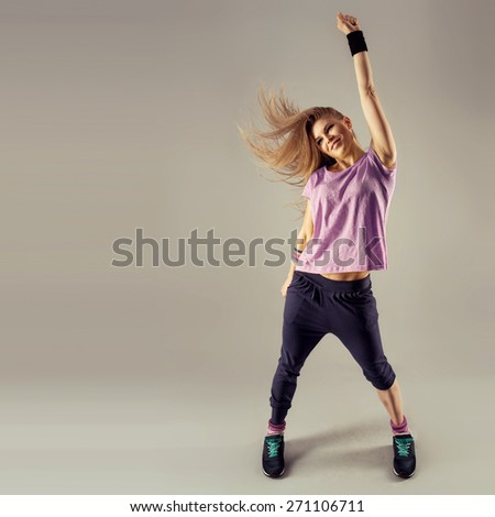 Break dance party. Stylish smiling fit woman dancing on studio background. Sport and recreation concept.