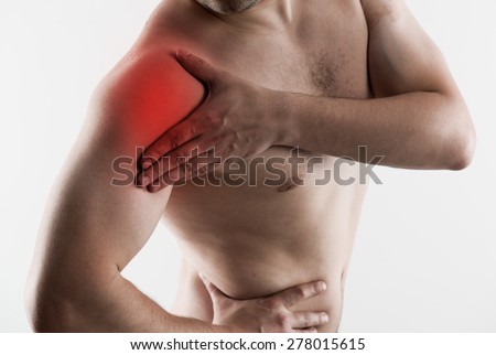 Shoulder joint fracture. Young man having rheumatism problem, touching his arm in pain.