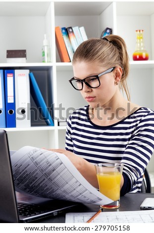 Young female accountant working with tax documents at home. Distance education and electronic business concept.