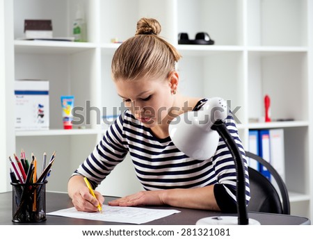 Female student working over house plan and design at home. Young woman drawing sketch at the table.