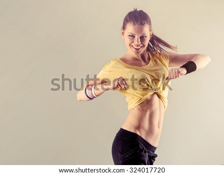 Aerobics fitness workout. Young athletic female dancing street dance in studio. Concept of sport and health.