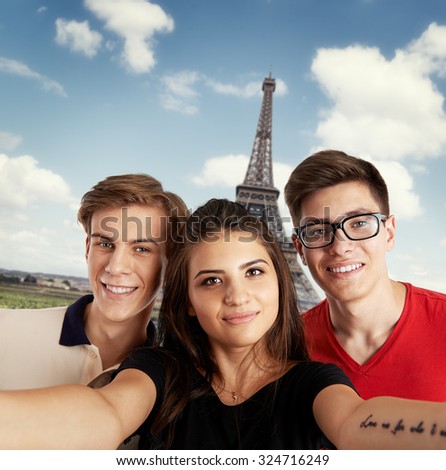 Group of students making selfie over Eiffel Tower background in Paris. Concept of travel, holidays and friendship.