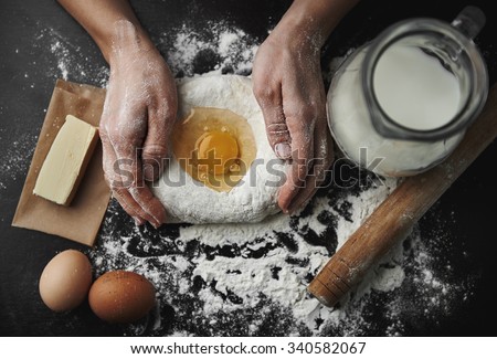 Professional female baker cooking dough with eggs, butter and milk for Christmas cookies.