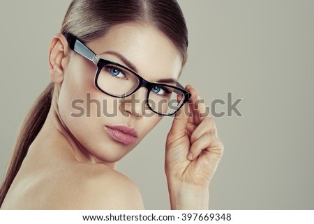 Clear vision concept. Beauty studio portrait of young pretty female wearing stylish eyeglasses with blank space.