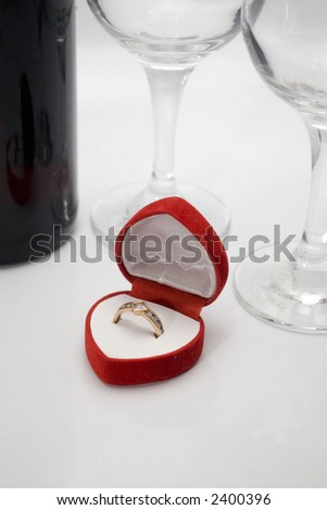 wedding ring, glasses and bottle of wine