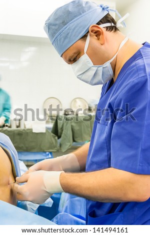 Doctor performing epidural anesthesia in the operating room