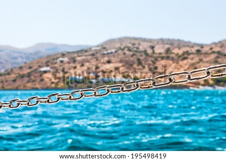 Steel Chain on the Sailing Boat with Coast at Background.