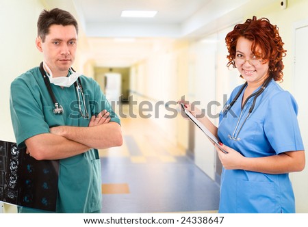 male and female doctor in long corridor under lamps.