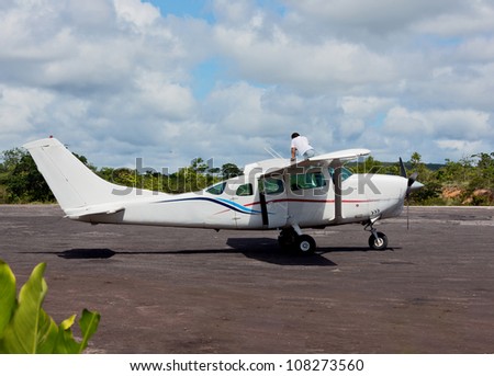 The mechanic is preparing the plane for take-off in the airport Canaima - Venezuela