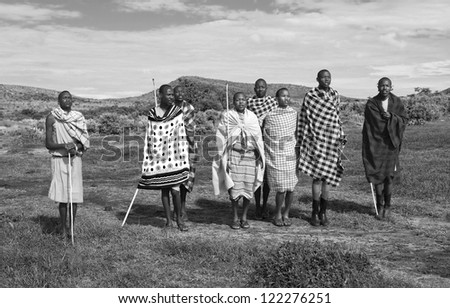 MASAI MARA, KENYA - DECEMBER 2: Masai warriors dancing traditional jumps as cultural ceremony. As well as women sing and dance. Masai Mara National Park, December 2, 2011 in Kenya