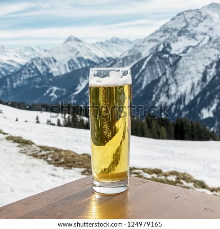 Glass of the fustrian beer against snow mountains a valley of Zillertal - Mayrhofen, Austria