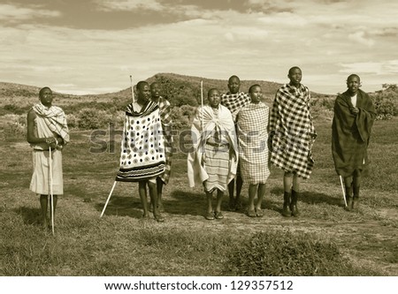 MASAI MARA, KENYA - DECEMBER 2: Masai warriors dancing traditional jumps as cultural ceremony. As well as women sing and dance. Masai Mara National Park, December 2, 2011 in Kenya (stylized retro)
