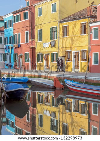 The reflection in the water channel of multi-colored houses - Burano, Venice, Italy