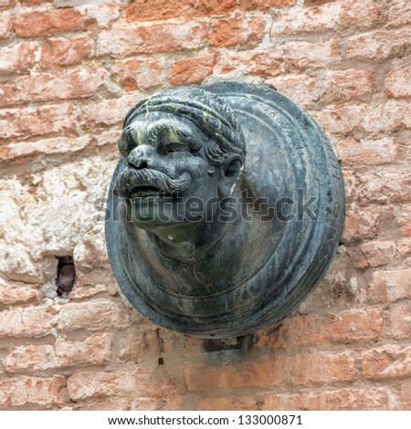 Ancient sculpture of a man's head on the wall of a Venetian home - Venice, Italy